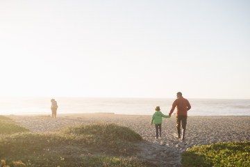 A family gazes into the mist on a beach