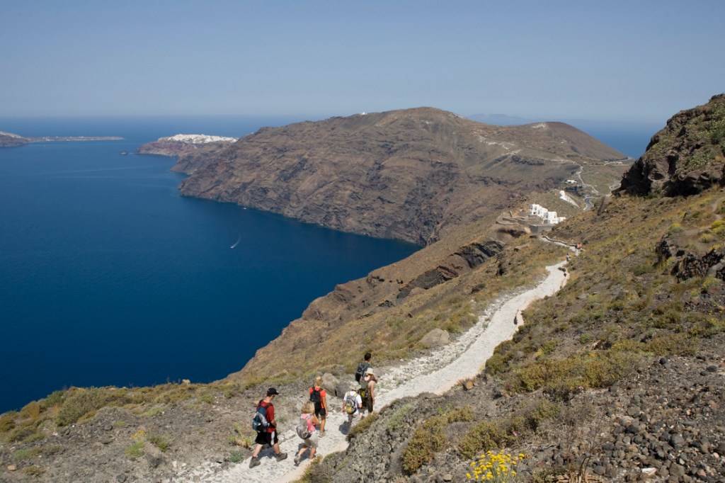 Hikers with an REI Adventures trip traverse a coastal trail.