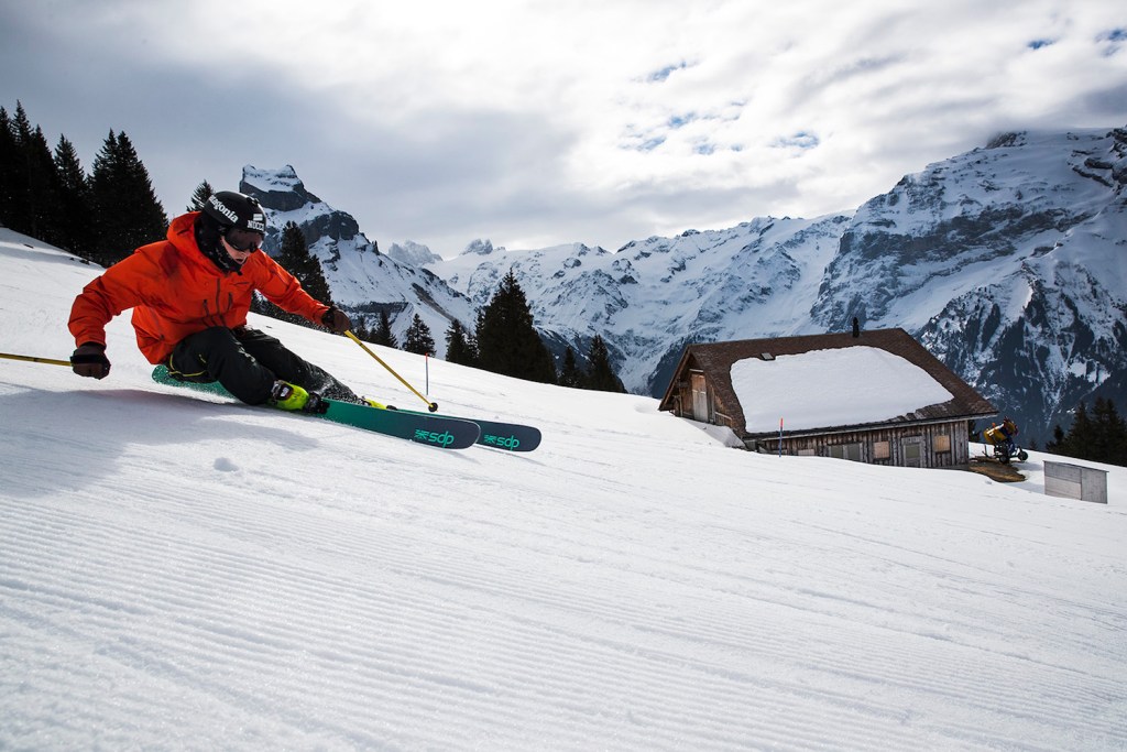 A skier on DPS Skis makes a turn on a groomer slope.