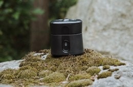 Thermacell Radius resting on moss on a gray rock.