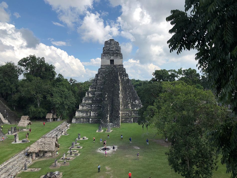 A central pyramid of Tikal rises from the jungle. 