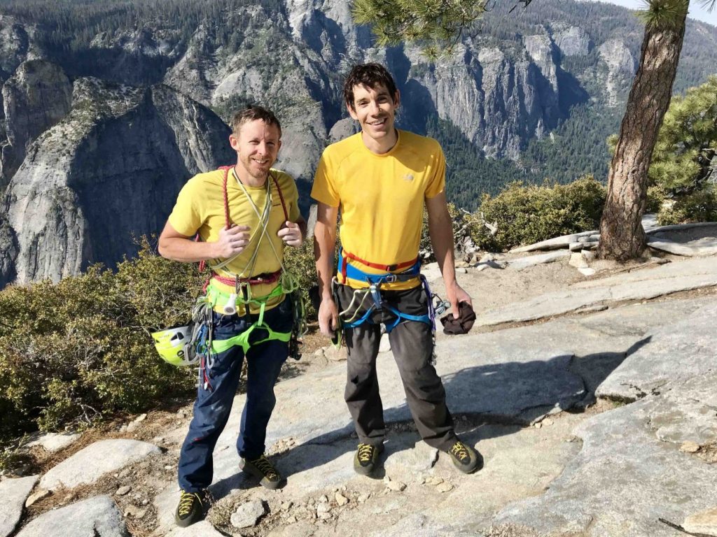 Tommy Caldwell and Alex Honnold in climbing gear on a summit in Yosemite.