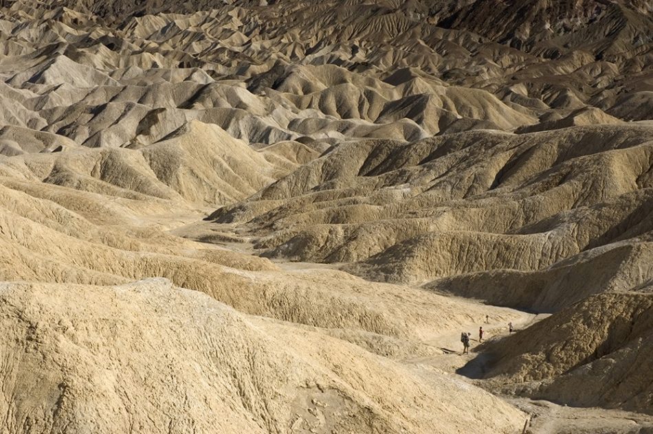 Hikers pass through a small wash in an arid corner of Death Valley National Park.