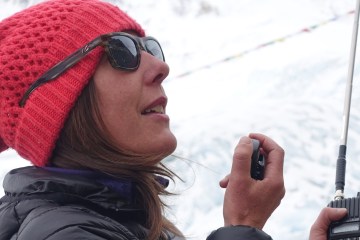 Dr. Monica Piris uses a radio to communicate at a high-altitude base camp.
