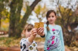 Two girls hold up Junior Ranger badges they collected