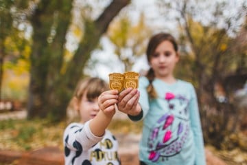 Two girls hold up Junior Ranger badges they collected