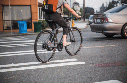 A woman biking in the middle of traffic.