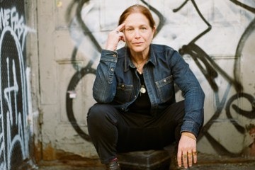 Karen Rinaldi in front of a graffiti wall.
