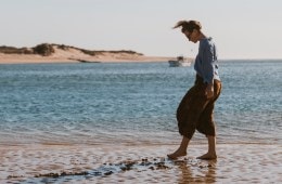 A lone women walks along the beach in Portugal.