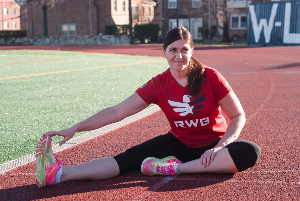 Dana Ayers stretches on a track before a run.