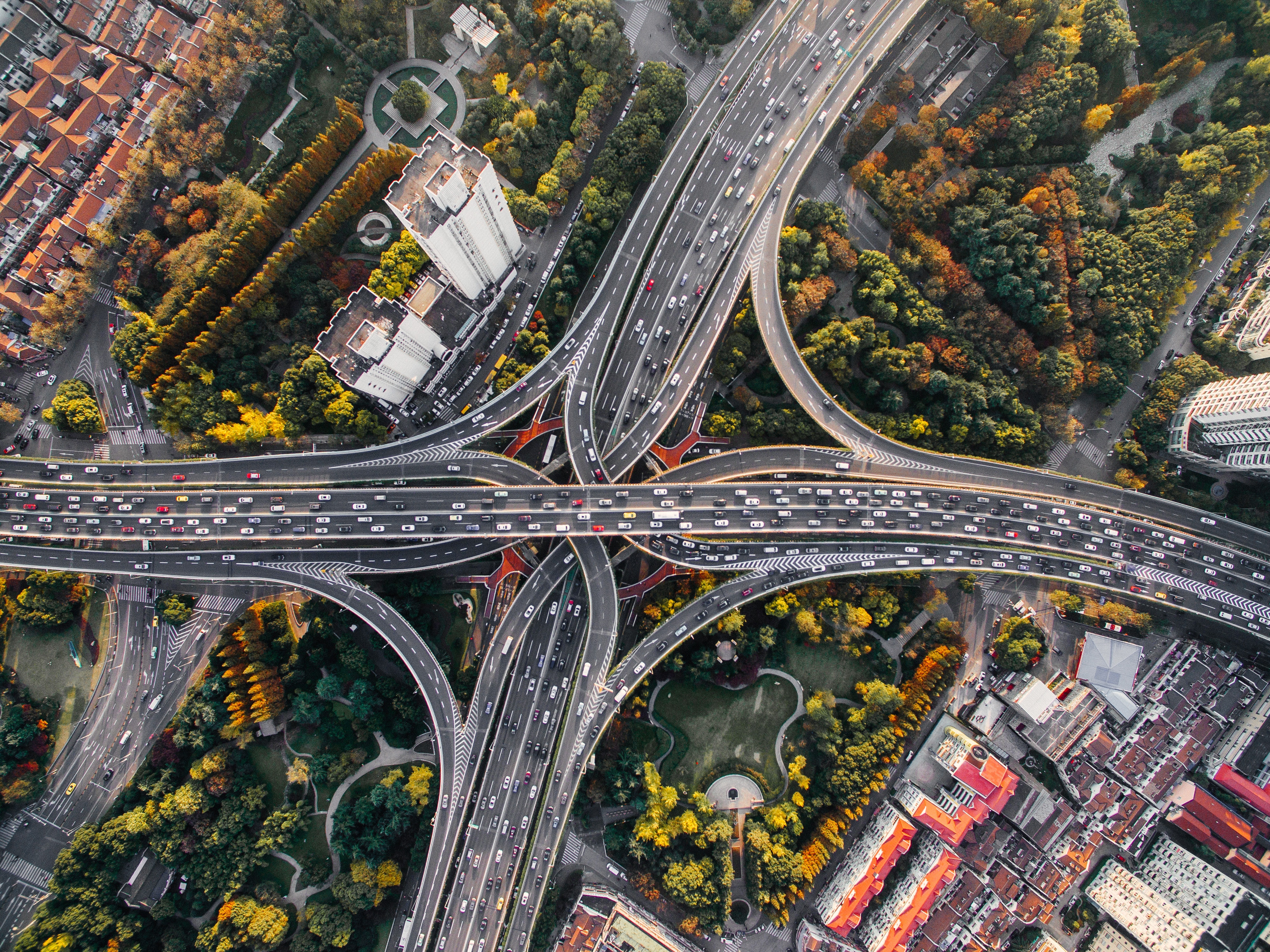 Overhead shot of highways surrounded by city forests.