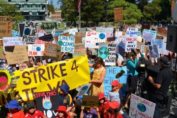 A shot of young people holding signs and protesting in bright clothing