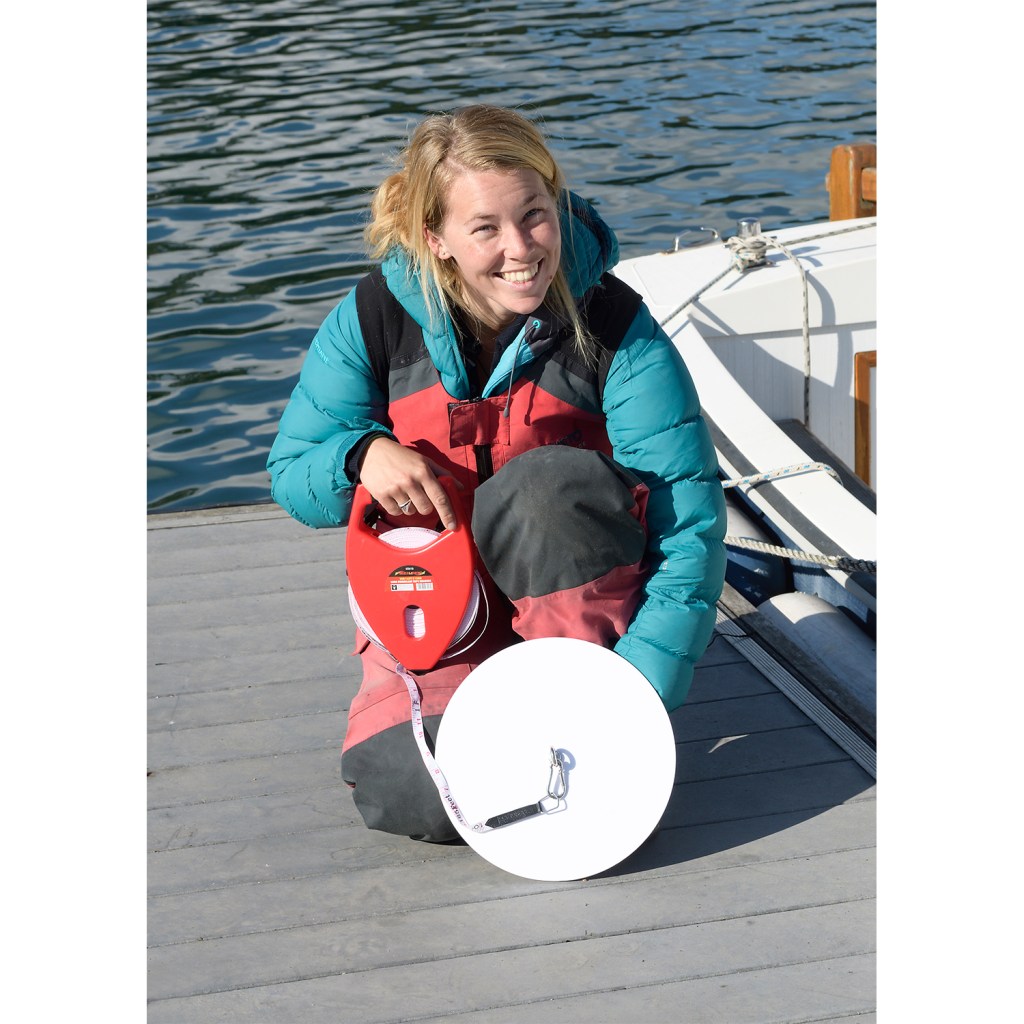 A sailor poses with a Secchi Disk
