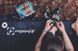 A woman prepares to go climbing by tightening her shoes
