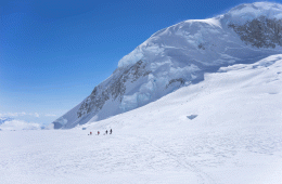 A team of mountaineers hauls gear up a snowy face