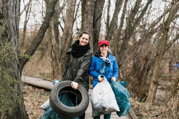 Two people cleaning up trash