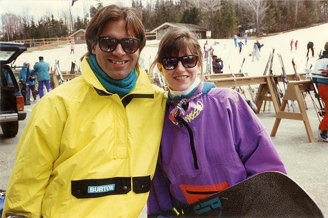 Two snowboarders pose for a photo in vintage '80s apparel.