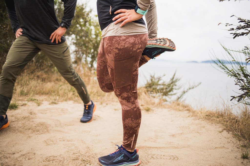 A runner stretches her quad before heading out.