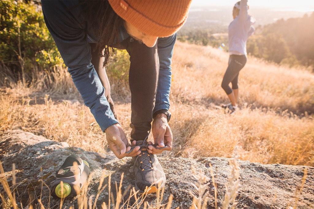 A runner ties his shoe laces before a run. 