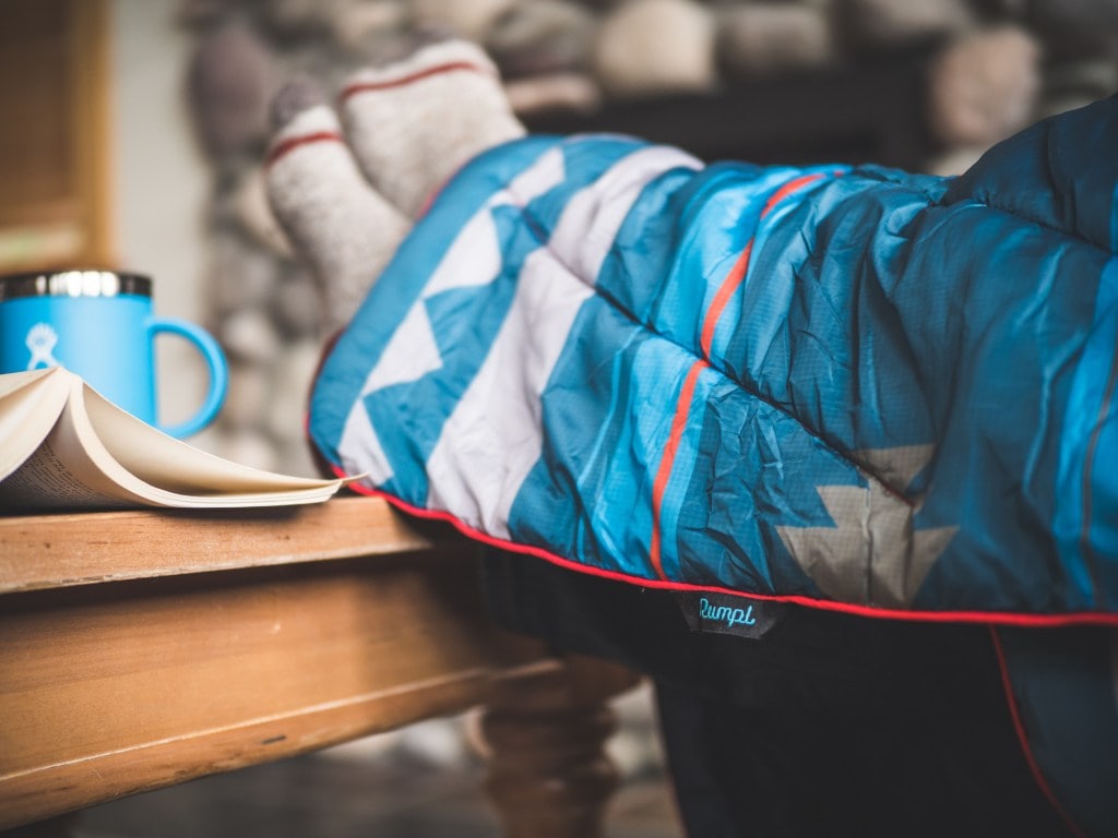 A person with stretched out legs and a blanket 
