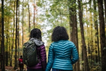 Two female hikers looking into the woods.