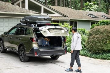 Woman packing up her Subaru in her driveway.