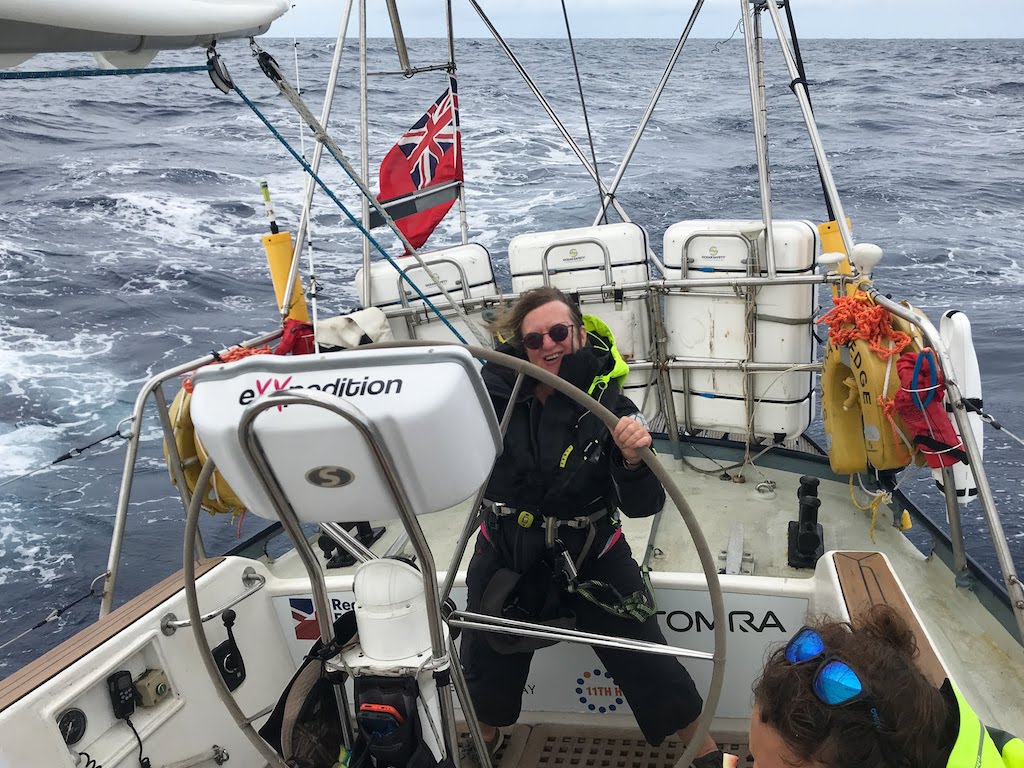 A woman at helm of sailboat