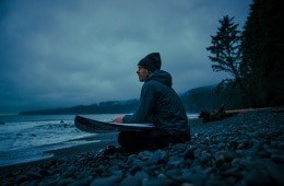 Chad Sayers sits on the beach looking out at the ocean.