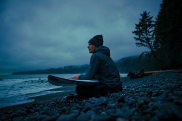 Chad Sayers sits on the beach looking out at the ocean.