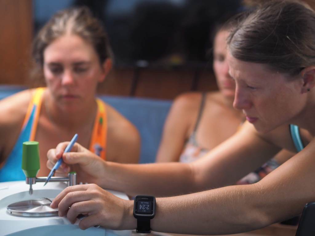 Woman analyzes sample of ocean plastic.