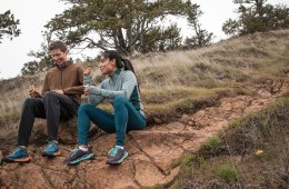 Runners sitting on a trail eating snacks