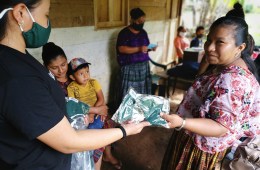 A woman distributes masks to aid with COVID-19 relief.