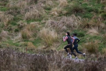 Two runners sprint uphill