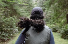 A woman jogs through a dense green forest