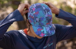 A woman secures a colorful hat to her head before taking off on a trail run