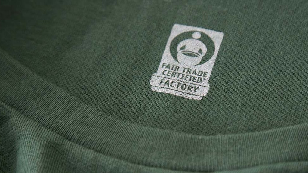 A Fair Trade Certified label inside a dark green T-shirt.