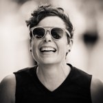 A black and white photo of a smiling runner wearing sunglasses