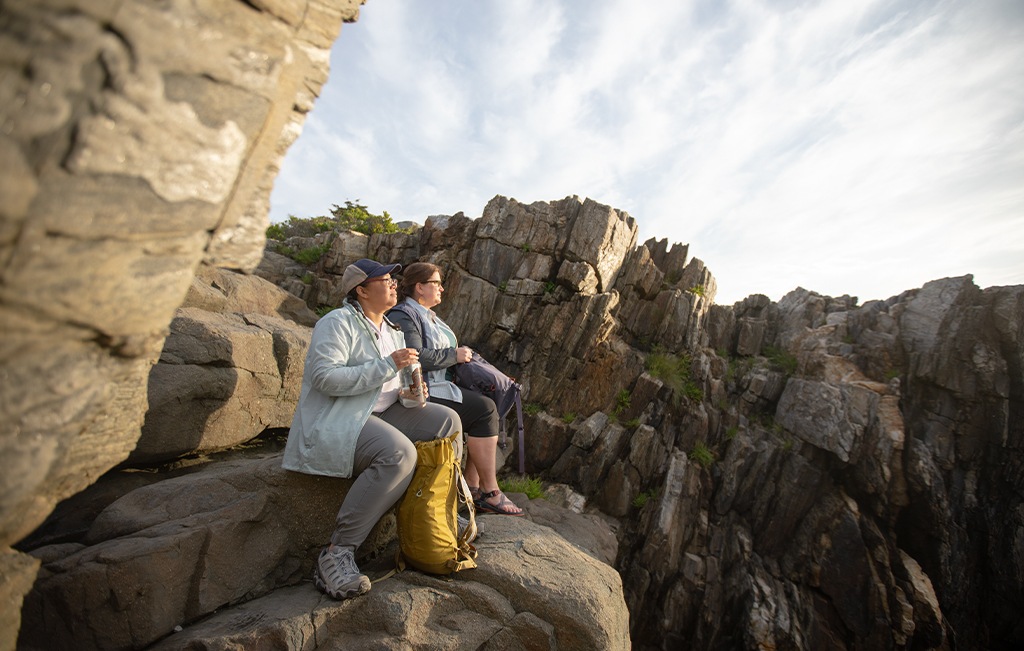 Two hikers taking a break on a rock ledge