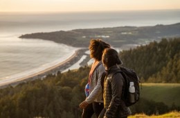 Two hikers looking out at a large body of water.