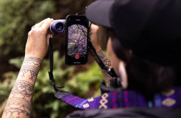 Artist Amelia Winger-Bearskin takes a photo through a pair of Nocs Binoculars