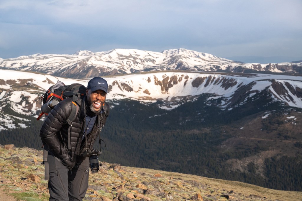 Hiker on a trail with mountains in the background