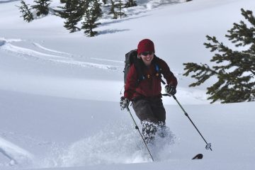 Stacy Gold skiing deep powder and smiling
