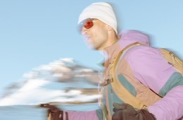 A person holding trekking poles moves along a snowy landscape.