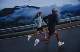 A man and a woman run on a foggy stretch of road in the On Cloudprime, featuring CleanCloud technology.
