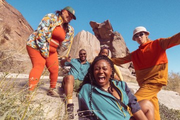 Five people wearing Trailmade apparel stand in the sunshine