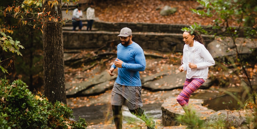 Two Black runners jogging in the forest.