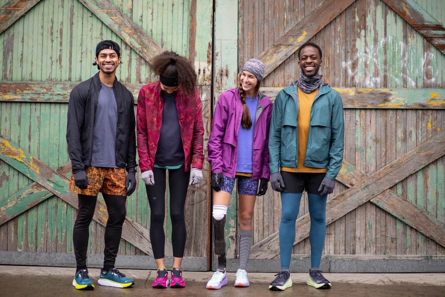 A diverse group of runners, including an adaptive athlete wearing a high-performance prosthetic on their right lower limb. 