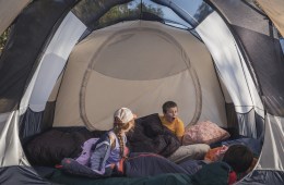Three kids inside a tent.