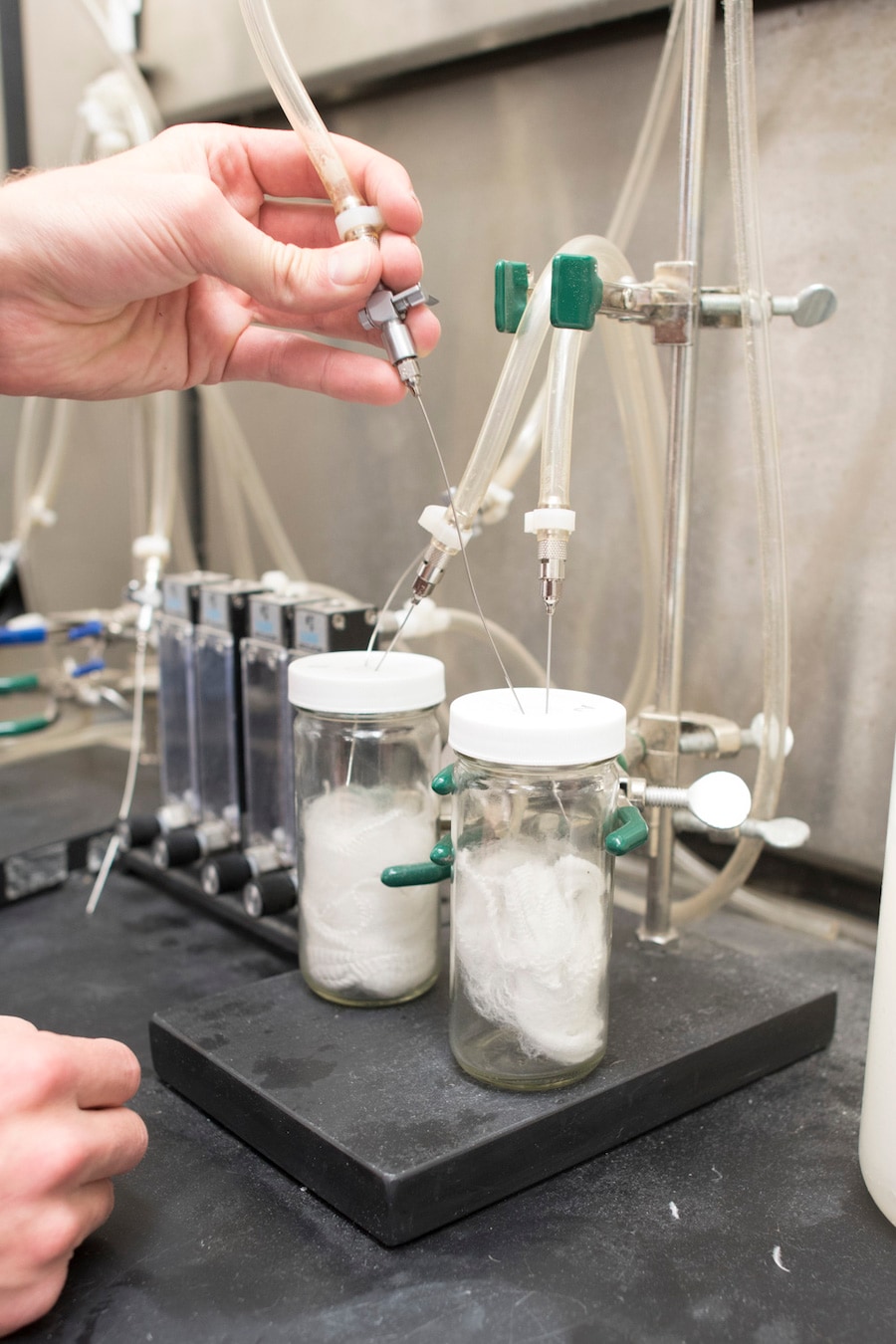 Cocona Labs scientist Taylor Hukari Testing Odor Absorbency in 37.5 fibers. Hukari places a pointy, syringe-like object inside a cylinder which contains 37.5 fibers. 