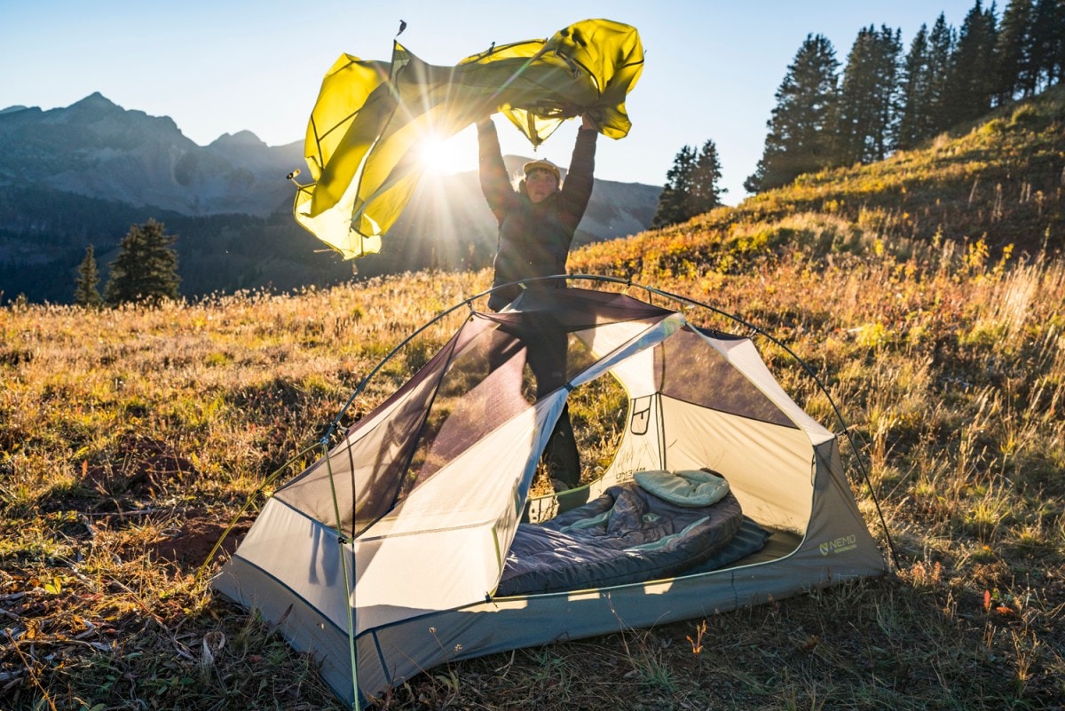 A camper shakes out a tent fly.
